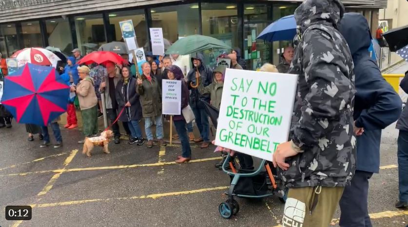 Photo of a group of protestors outside a council office building.